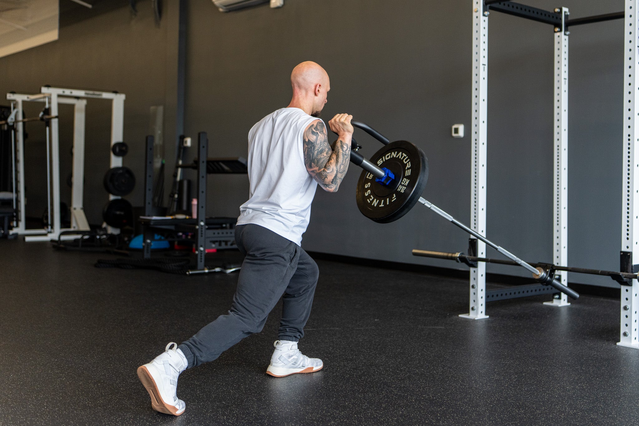 A lifter performing a split-stance landmine press
